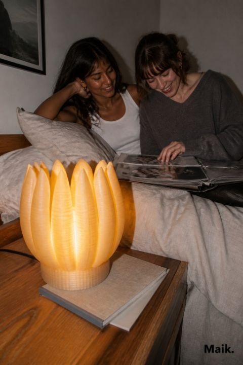 Tulip lamp lit on a bedside table